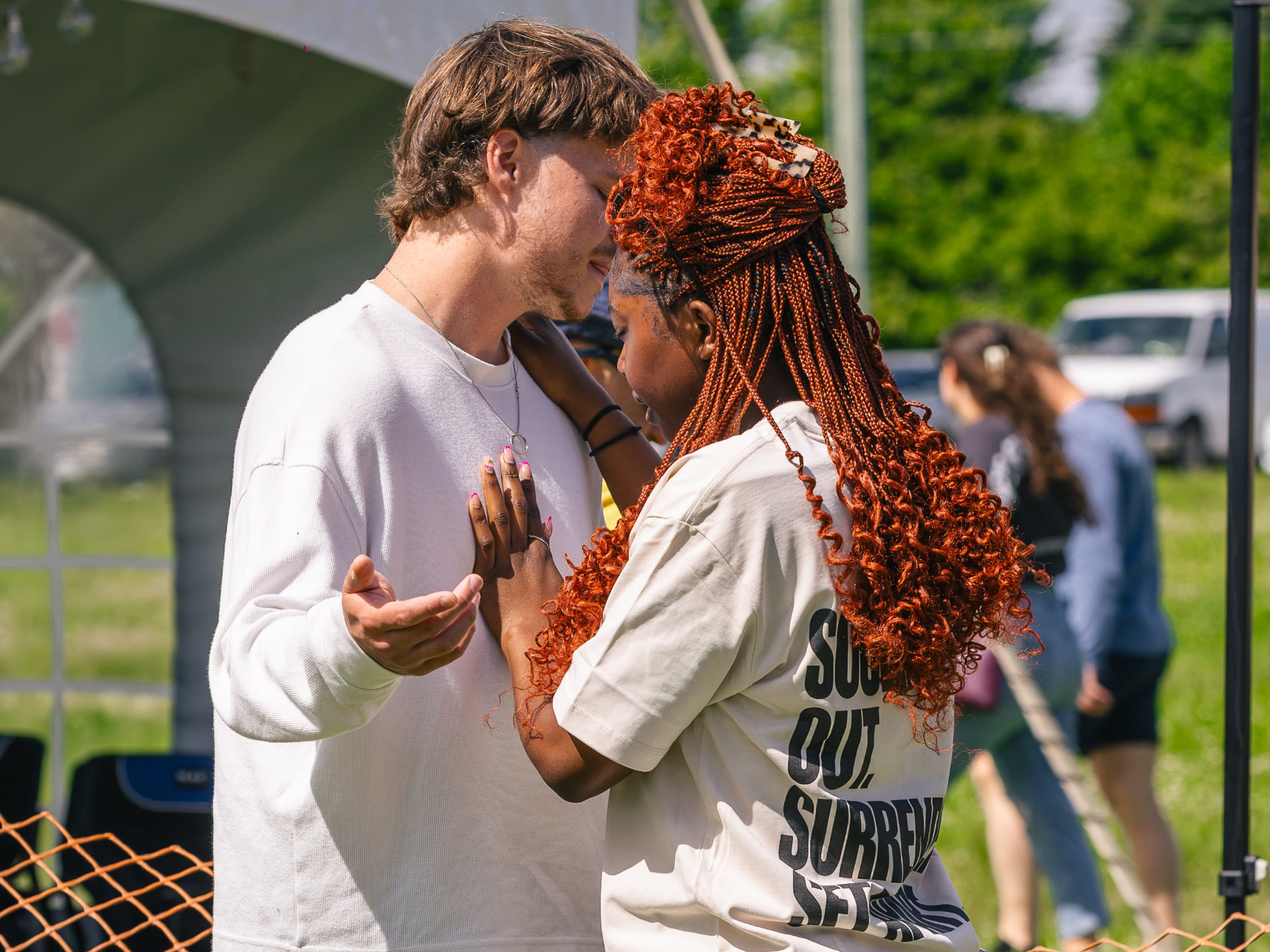 Two young people praying together outdoors