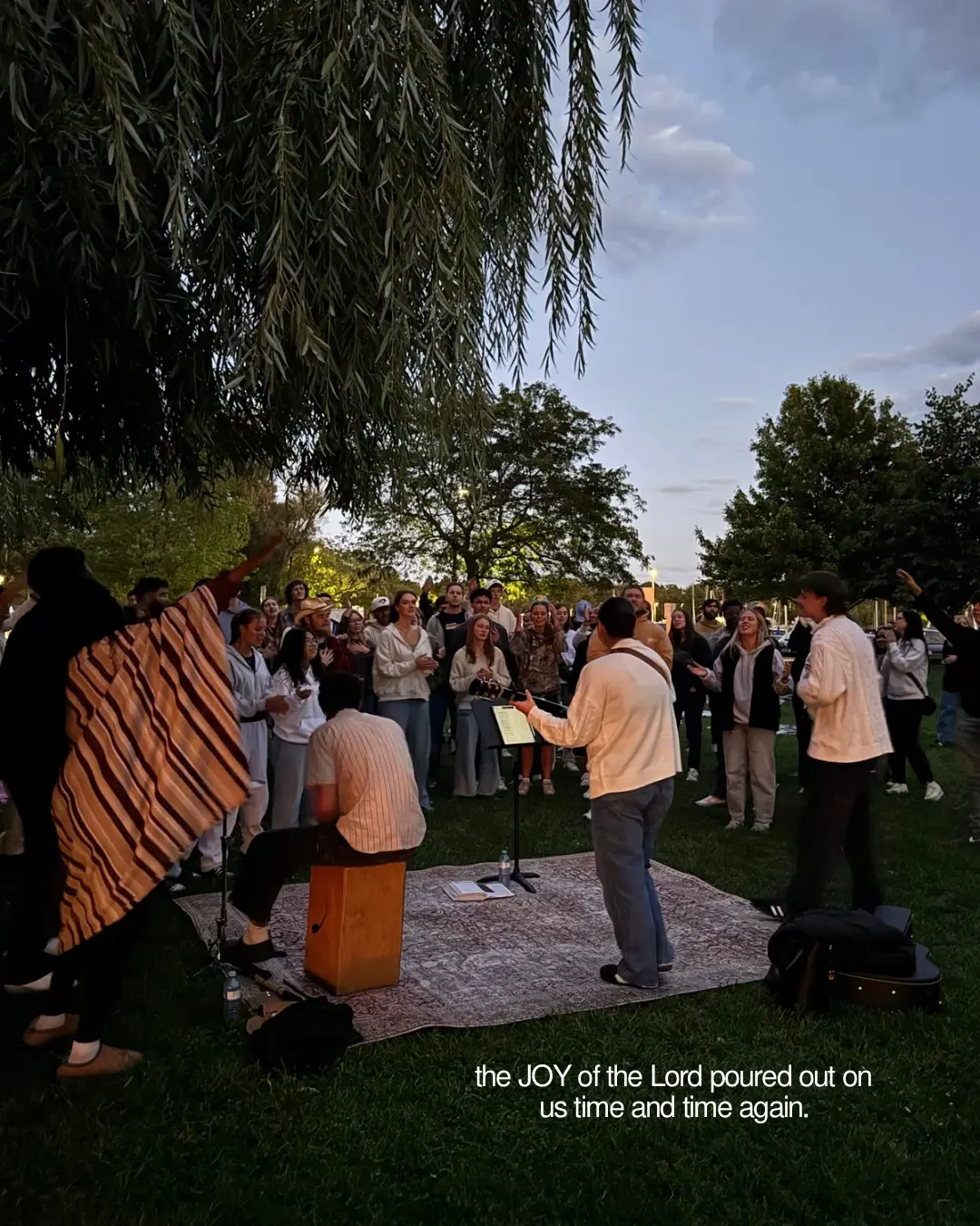 The Souled Out community worshipping outdoors beneath the trees