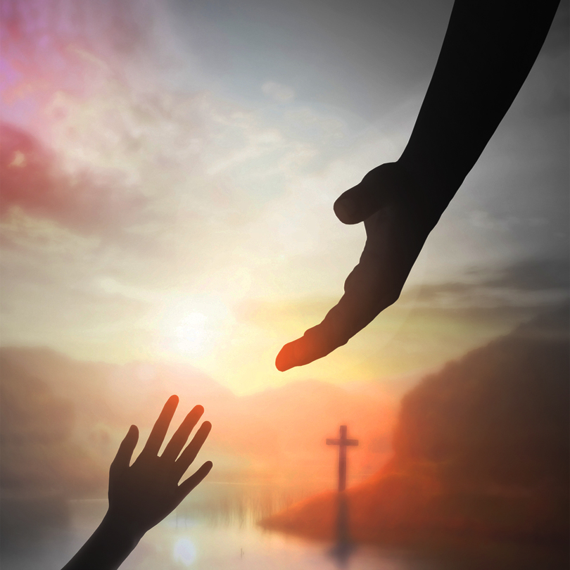 Hands reaching toward one another with a cross in the background