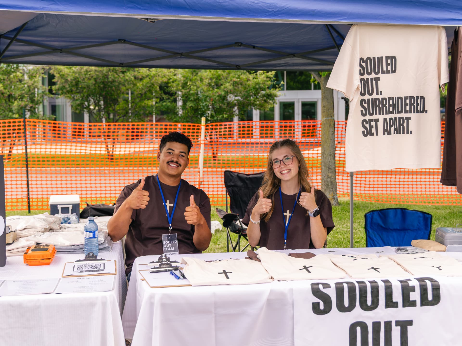 The Souled Out team at the merch table under the Surrendered, Set Apart banner