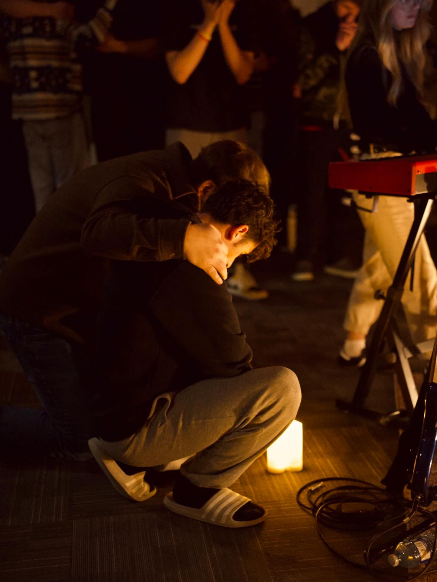 Two people supporting one another in prayer during worship