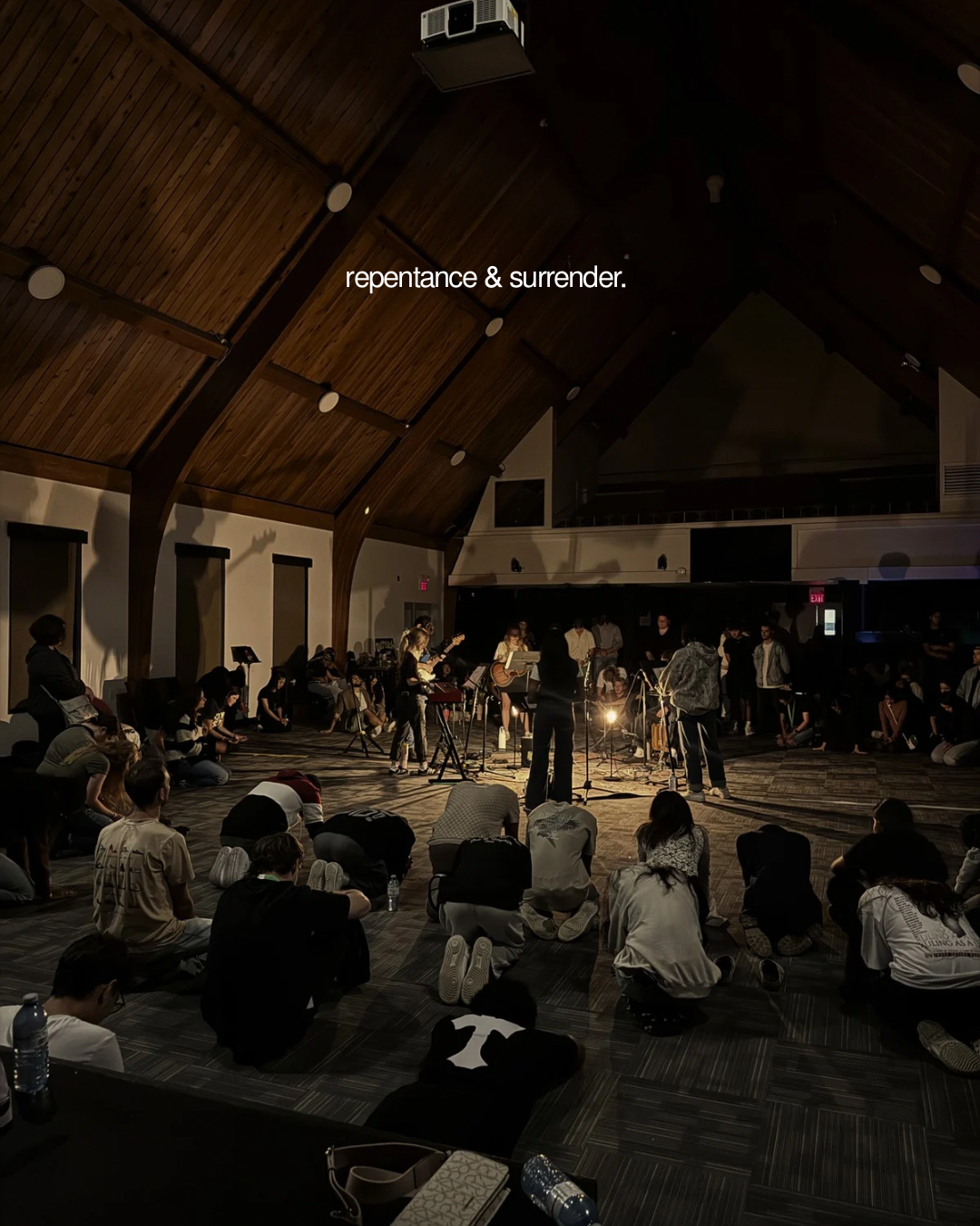 Worshippers kneeling in surrender during a chapel gathering